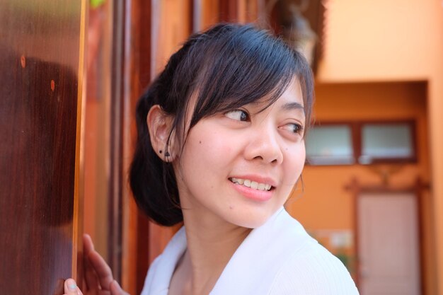 Photo close-up of young woman standing against door