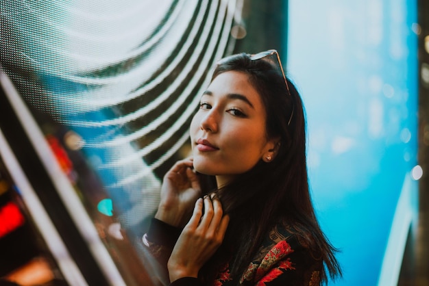 Photo close-up of young woman standing against illuminated city at night