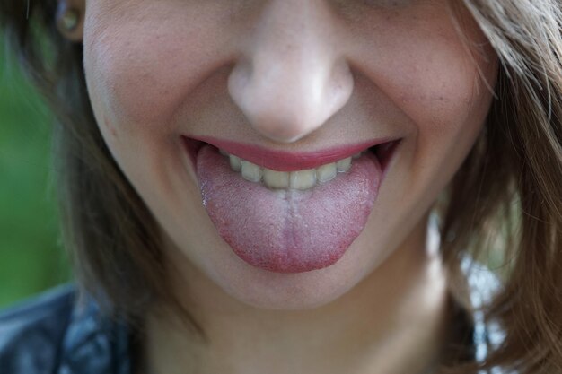 Photo close-up of young woman sticking out tongue