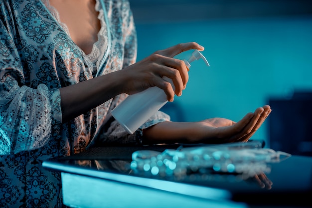 Close up: A young woman treats her hands with antiseptic gel. Infection prevention