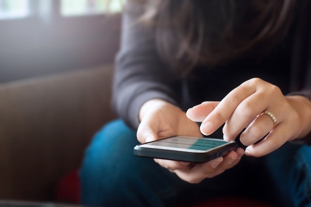 Vicino giovane donna utilizzando smart phone mobile in un caffè