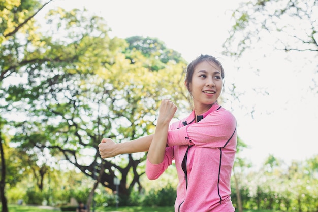 Close up of a young woman warm up her body by stretching her arms