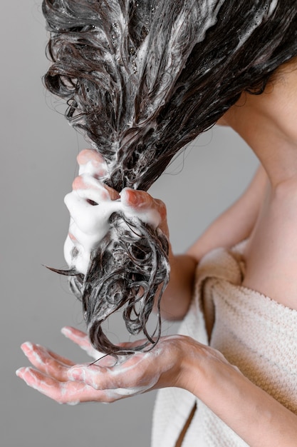 Close-up young woman washing hair