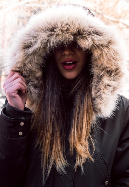Foto close-up di una giovane donna che indossa un cappotto di pelliccia