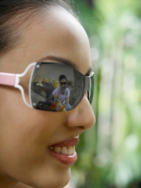 Foto close-up di una giovane donna che indossa occhiali da sole