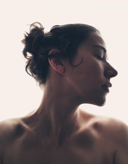 Photo close-up of young woman with eyes closed against white background