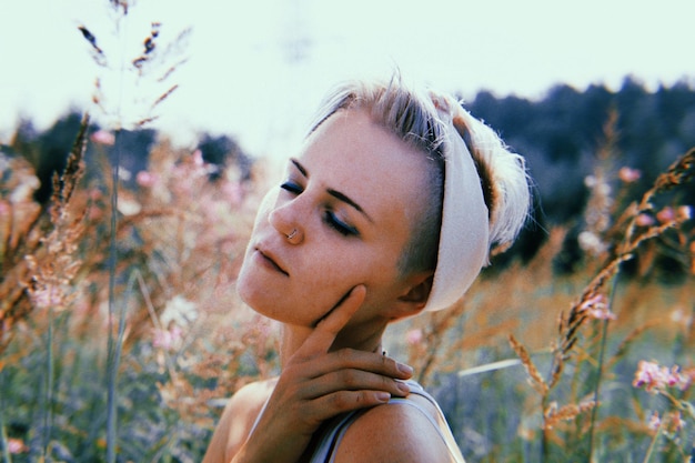 Foto close-up di una giovane donna con gli occhi chiusi dalle piante