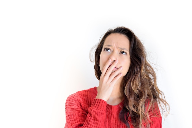 Photo close-up of young woman with hand covering mouth against white background