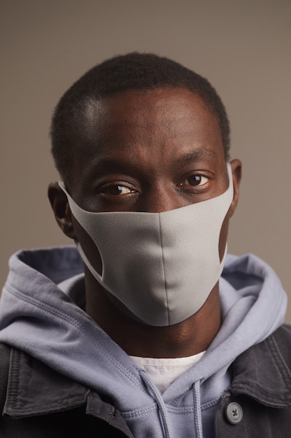 Close-up of young young man posing at front in protective mask