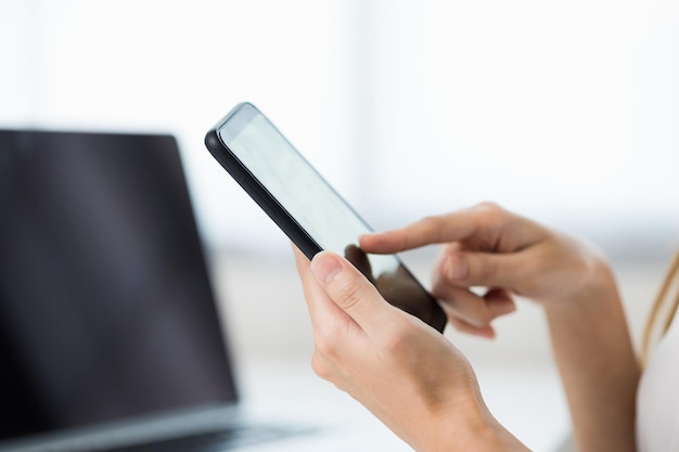 Close-up zakelijke vrouw handen met behulp van smartphone. Jonge vrouwelijke sms'en aanraken op het display van de mobiele telefoon.