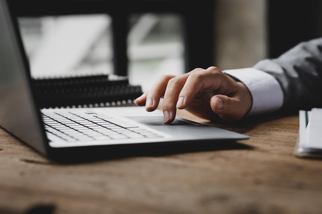 Close-up zakenman aan het werk in een privékamer Hij typt op het toetsenbord van een laptop Hij gebruikt een messenger om met een partner te chatten Concept van het gebruik van technologie in communicatie