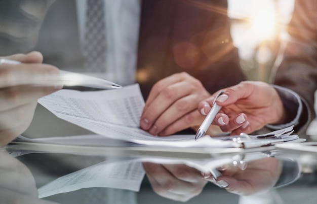 Close-up zakenman financieel verslag kijken en aantekeningen maken met een pen erin