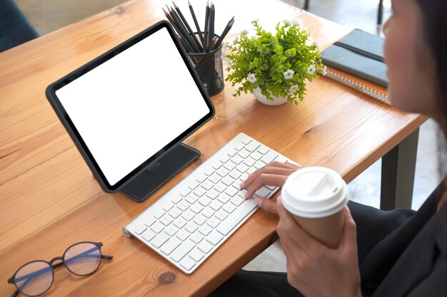 Close-up zakenvrouw koffie drinken en werken met digitale tablet