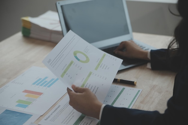 Close-up zakenvrouw met behulp van rekenmachine en laptop voor do math finance op houten bureau fiscale boekhoudstatistieken en analytisch onderzoeksconcept