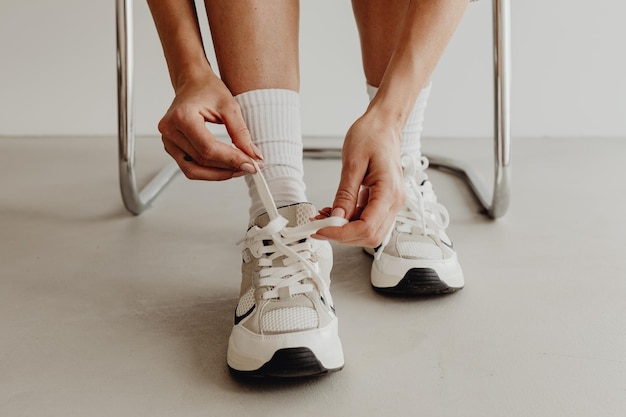 Close-up zakenvrouw trekt haar schoenen uit en trekt witte leren sneakers aan