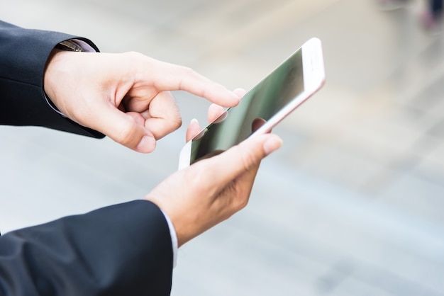 close-up Zijaanzicht beeld van mannelijke handen met behulp van moderne slimme telefoon buiten, hispter man lopen in de zon