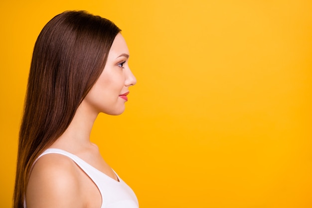 Close-up zijprofiel mooie brunette poseren geïsoleerd op oranje