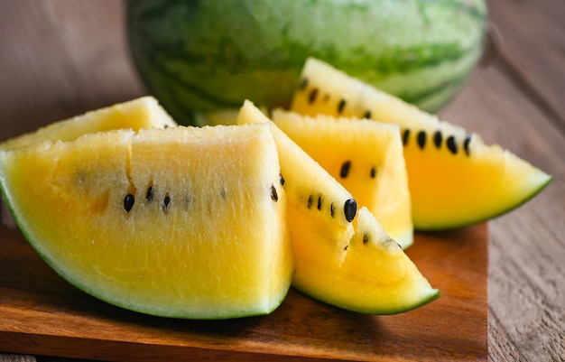 Close-up zoete watermeloen plakjes stukjes verse watermeloen tropisch zomerfruit Geel watermeloen plakje op houten achtergrond