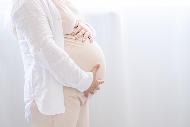 close-up zwangere vrouw streelt haar dikke buik. Prenatale kraamzorg