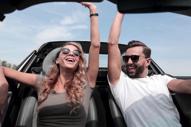 Close upa happy couple travelling in a convertible