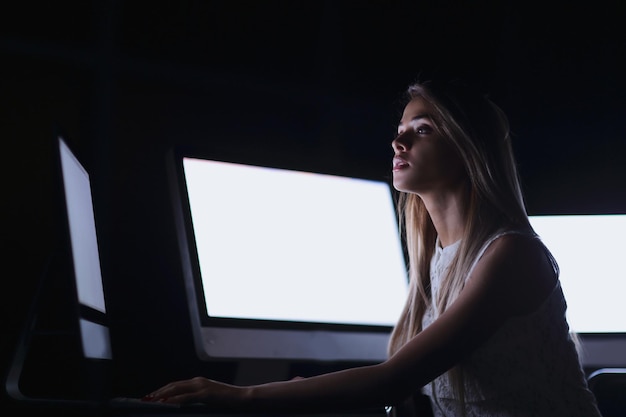 Close upa young woman near the desktopthe concept of ebusiness