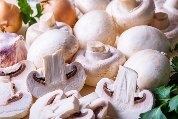 Close-upachtergrond van hele en gesneden champignons met andere kookingrediënten. Selectieve aandacht.