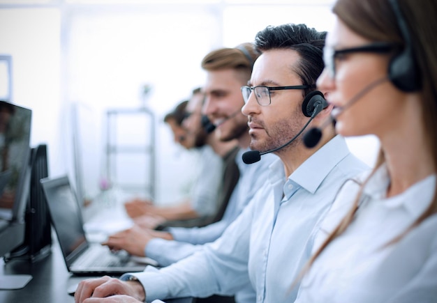 Close upbackground image of call center employees in the workplace