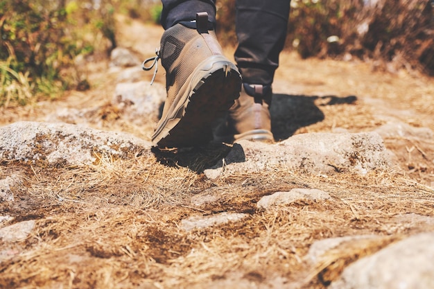 Close-upbeeld van de benen van een vrouw met trekkingschoenen op de top van de berg