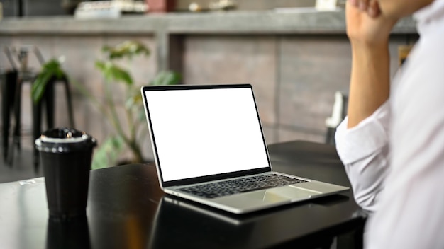 Close-upbeeld van een Aziatische zakenman die aan zijn werk op laptop werkt