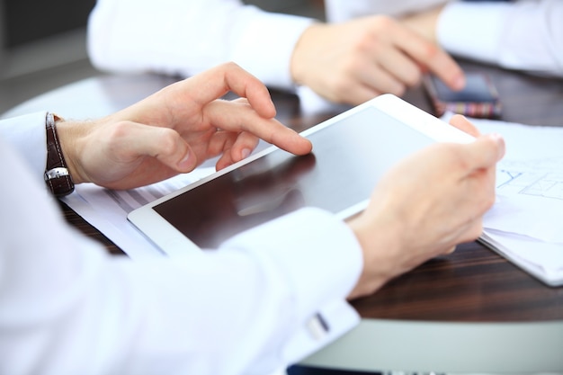 Close-upbeeld van een kantoormedewerker die een touchpad gebruikt om statistische gegevens te analyseren