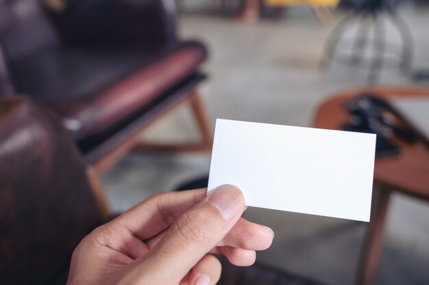 Close-upbeeld van een man hand die leeg adreskaartje in koffie houden