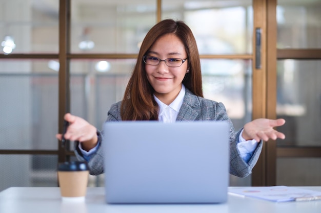 Close-upbeeld van een mooie zakenvrouw die een laptop gebruikt om online te werken en videoconferenties te houden