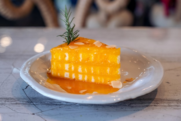 Close-upbeeld van een stuk oranje cake op ceramische plaat