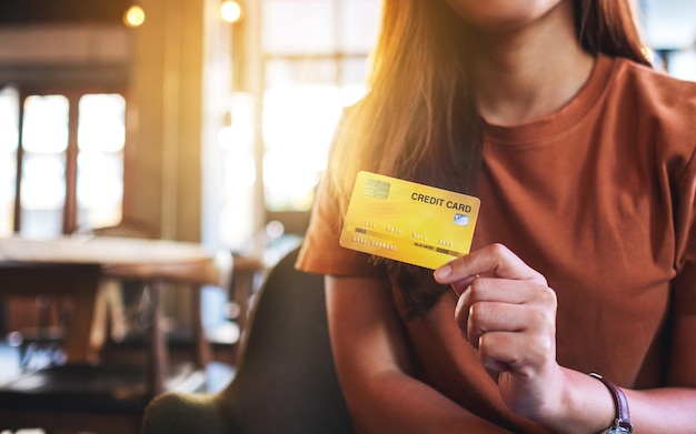 Close-upbeeld van een vrouw die creditcard vasthoudt en toont
