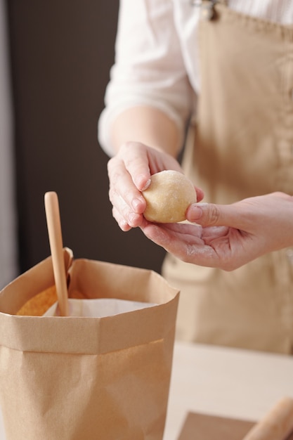 Close-upbeeld van een vrouw die deegballen bedekt met witte bloem bij het maken van mooncakes voor een feestje