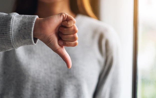 Close-upbeeld van een vrouw die duimen omlaag handen tekent