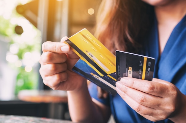 Close-upbeeld van een vrouw die een creditcard vasthoudt en kiest om te gebruiken