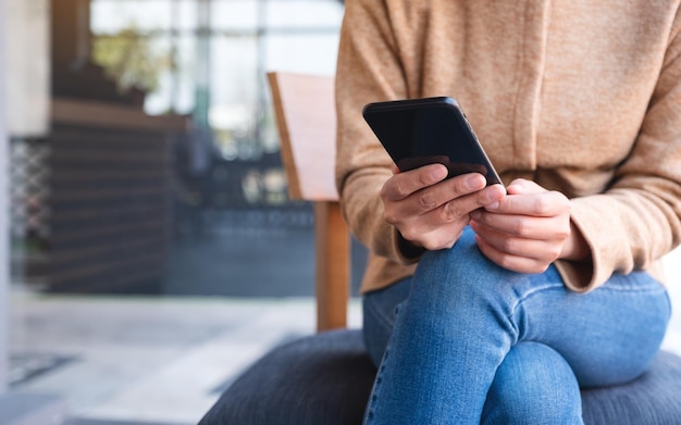 Close-upbeeld van een vrouw die een mobiele telefoon vasthoudt en gebruikt