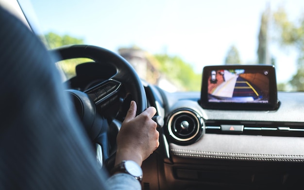 Close-upbeeld van een vrouw die het stuur vasthoudt terwijl ze een auto op de weg bestuurt