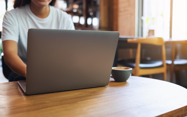 Close-upbeeld van een vrouw die laptopcomputer gebruikt en eraan werkt