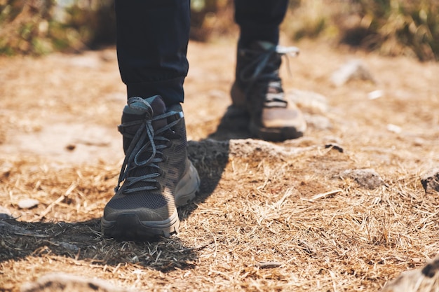 Close-upbeeld van een vrouw die met trekkingschoenen op de bovenkant van berg wandelt