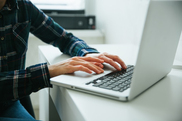 Close-upbeeld van hand die en op laptop toetsenbord gebruiken typt