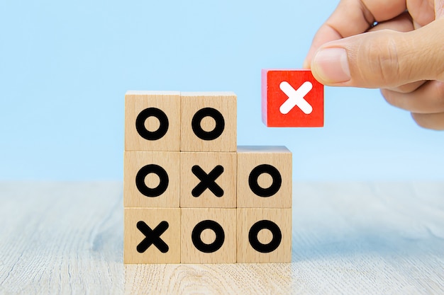 Close-upbeeld van met de hand geplukte kubusvormige houten speelgoedblokken met X-symbool.