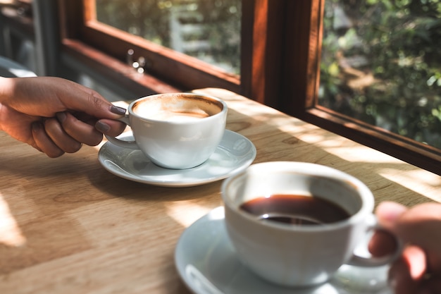 Close-upbeeld van twee mensen die en koffie in de ochtend houden drinken