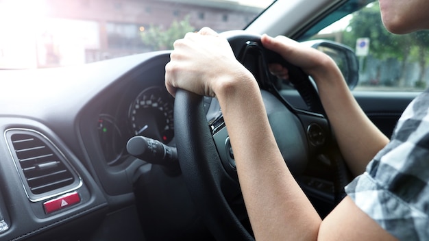 Close-upbeelden van vrouwenhanden die de auto met vertrouwen en veiligheid besturen en besturen, welke auto?