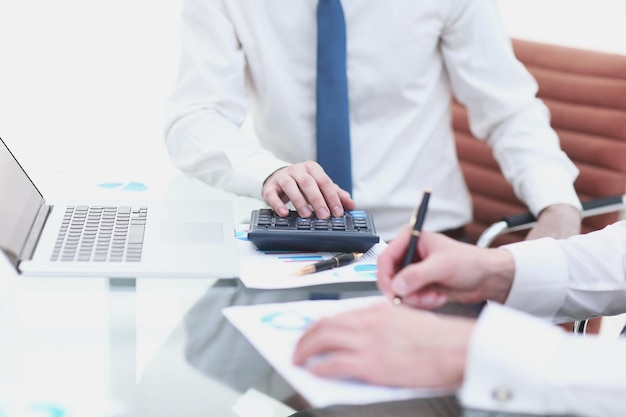 Foto chiuda in sucolleghi di lavoro che compilano la relazione finanziaria