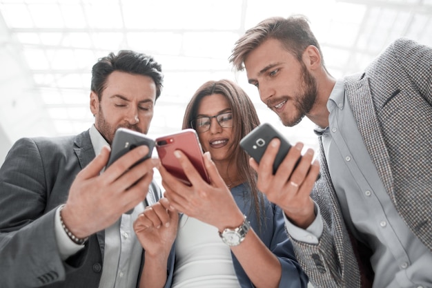 Close upbusiness colleagues reading SMS on their smartphones