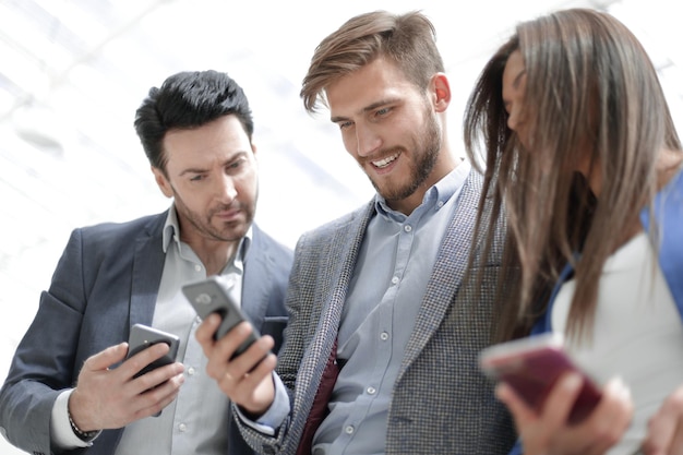 Photo close upbusiness colleagues reading a text on smartphonespeople and technology