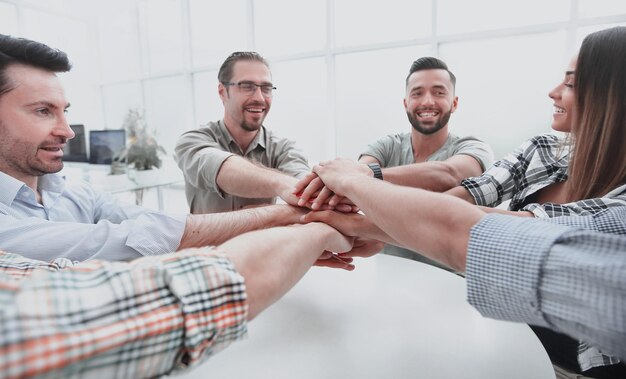 Close upbusiness team folded their palms together over the Desk