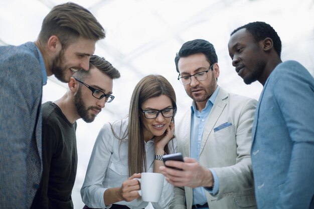 Photo close upbusiness team looking carefully at the smartphone screen